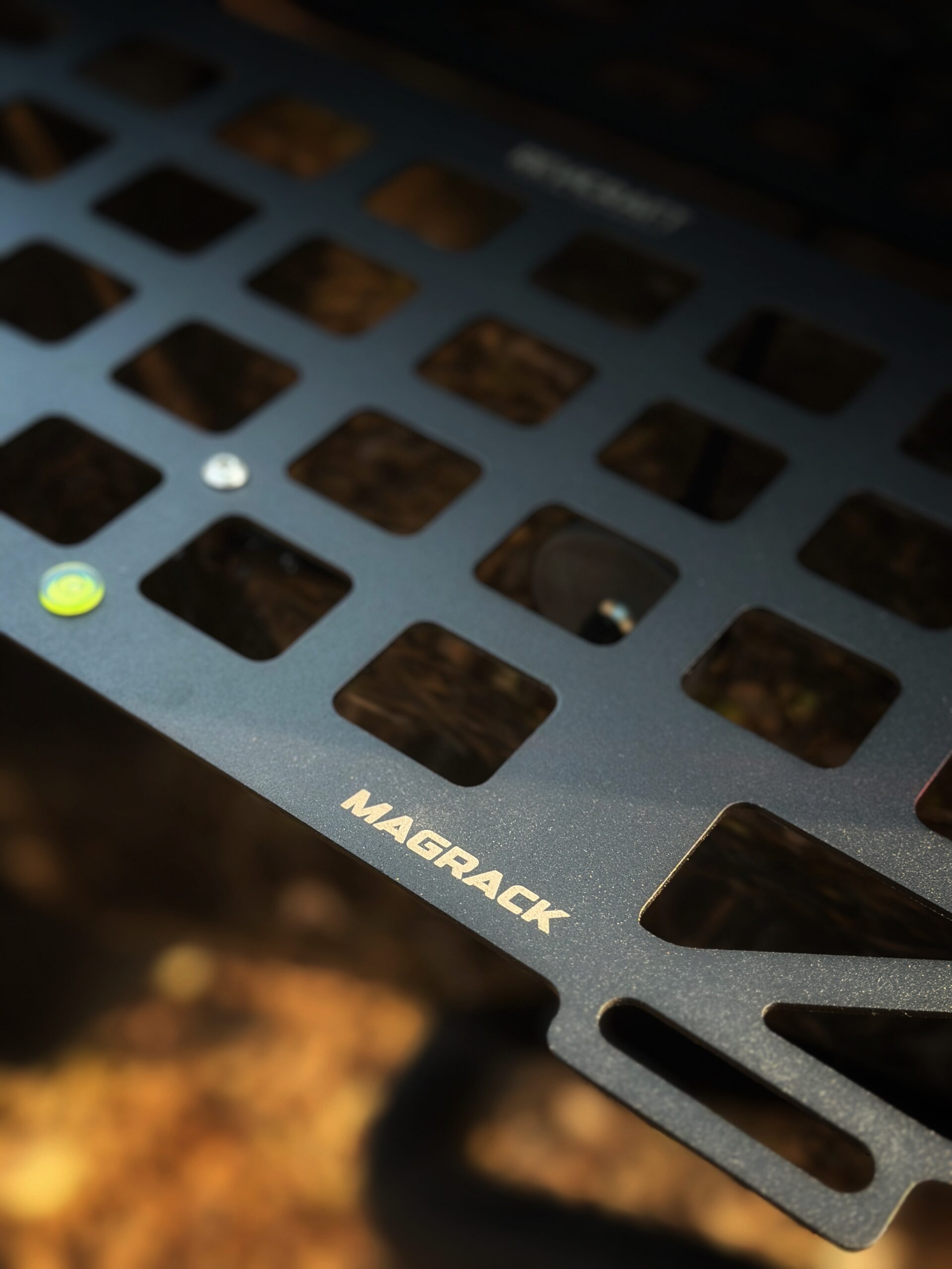 RevCraft MagRack magnetic outdoor tray mounted on a 4x4 steel surface, close-up of three rubber coated magnets on MagRack tray, RevCraft MagRack tray showing embedded spirit level, MagRack outdoor tray with cross bar support for stability, MagRack tray holding coffee cups and snacks during camping, RevCraft MagRack used as a cooking prep tray at an overlanding campsite, MagRack tray mounted on a 4x4 body panel during a roadside stop, RevCraft MagRack powder coated steel tray product close-up, MagRack tray load test with tools and gear, RevCraft MagRack tray packed inside protective carry bag, MagRack tray stored in vehicle trunk for travel, RevCraft MagRack magnetic tray mounted on a 4x4 tailgate, MagRack tray used for organizing recovery gear, RevCraft MagRack outdoor tray used for city dine-in setup, MagRack tray mounted on a steel roof rack side, close-up of MagRack cross bar and mounting structure, RevCraft MagRack tray holding camera gear safely, MagRack tray leveled using spirit level for hot drinks, RevCraft MagRack tray in overland setup with cookware, MagRack magnetic tray for 4x4 camping and outdoor use