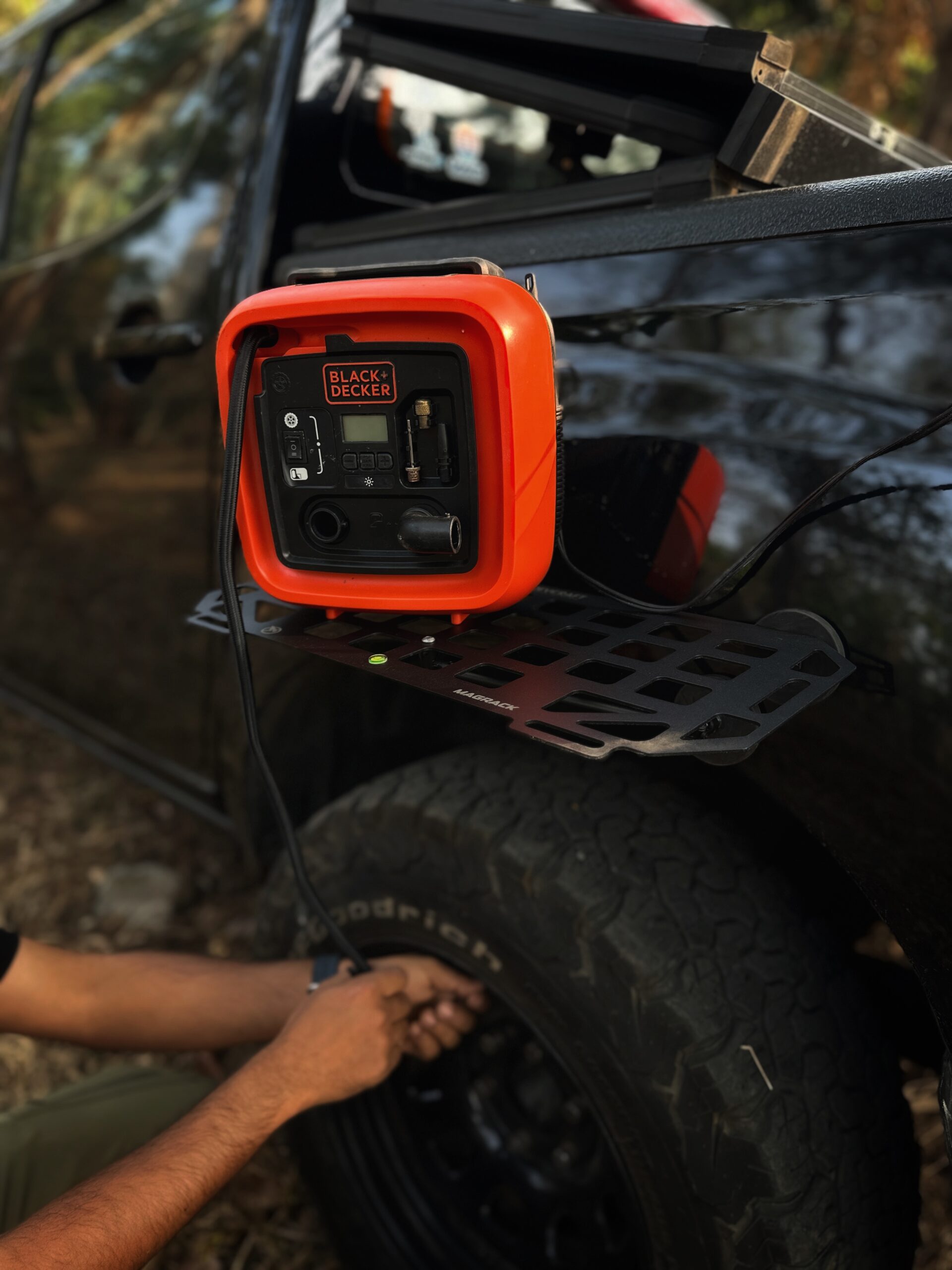 RevCraft MagRack magnetic outdoor tray mounted on a 4x4 steel surface, close-up of three rubber coated magnets on MagRack tray, RevCraft MagRack tray showing embedded spirit level, MagRack outdoor tray with cross bar support for stability, MagRack tray holding coffee cups and snacks during camping, RevCraft MagRack used as a cooking prep tray at an overlanding campsite, MagRack tray mounted on a 4x4 body panel during a roadside stop, RevCraft MagRack powder coated steel tray product close-up, MagRack tray load test with tools and gear, RevCraft MagRack tray packed inside protective carry bag, MagRack tray stored in vehicle trunk for travel, RevCraft MagRack magnetic tray mounted on a 4x4 tailgate, MagRack tray used for organizing recovery gear, RevCraft MagRack outdoor tray used for city dine-in setup, MagRack tray mounted on a steel roof rack side, close-up of MagRack cross bar and mounting structure, RevCraft MagRack tray holding camera gear safely, MagRack tray leveled using spirit level for hot drinks, RevCraft MagRack tray in overland setup with cookware, MagRack magnetic tray for 4x4 camping and outdoor use