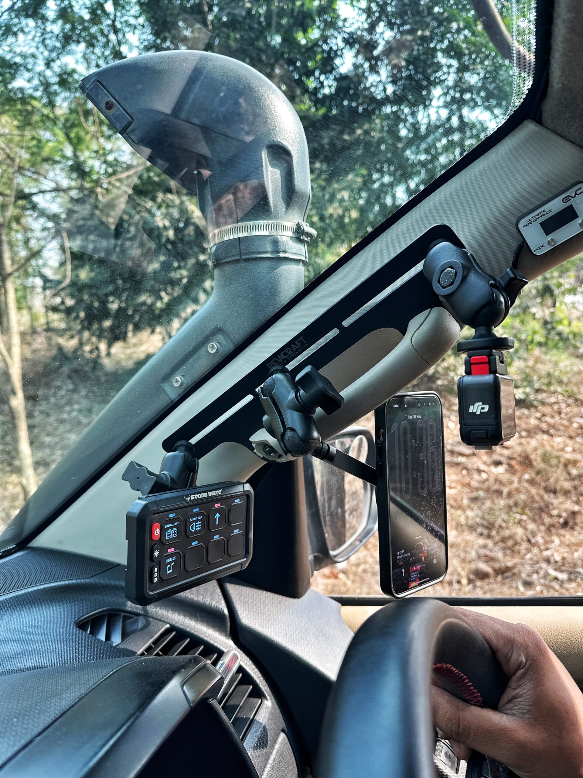 RevCraft A-Pillar Mount bracket with triple 1-inch ball base installed inside 4x4 cabin, Modular A-pillar mounting bracket with 3 one-inch ball mounts, 4x4 A-pillar accessory mount with universal 1-inch ball system, RevCraft A-Pillar Mount installed on vehicle A-pillar with modular ball mounts, Cabin A-pillar bracket holding 1-inch ball mounting system, Interior A-pillar mount setup for phone walkie and camera modules, Close-up of RevCraft A-Pillar bracket with three 1-inch ball mounts, Textured metal A-pillar mounting bracket with ball system, Modular A-pillar mount base with universal ball joints, A-pillar mount holding action camera inside off-road vehicle, Modular cabin mount supporting phone and camera on A-pillar, 4x4 interior A-pillar mounting system in use